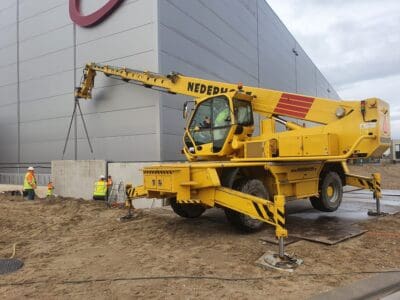 Het plaatsen van betonnen wanden met een roterende verreiker